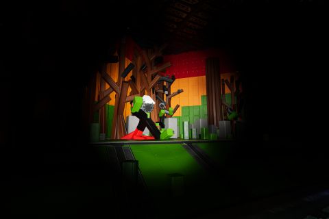 Image from the game Satisfactory featuring a scene from a halloween-themed on-rails attraction, with this particular scene depicting two people chasing another through some woods.