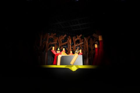 Image from the game Satisfactory featuring a scene from a halloween-themed on-rails attraction, with this particular scene featuring a small crowd of people surrounding a human sacrifice.