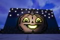 Image from the game Satisfactory a pumpkin depicted using a cartoon/pixel art style, with glowing stars in the background, glowing eyes on the pumpkin, and glowing open smile.