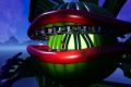 Image from the game Satisfactory featuring a depiction of the character "Audrey II" from the film "The Little Shop of Horrors". The character is largely made using the game's pipes, the shot focuses on the mouth of the character, showing that it has a statue of the game's creature commonly known as a "Bean".