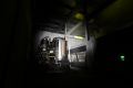 Image from the game Satisfactory featuring a scene from a haunted house attraction depicting the interior of a power distribution facility, this particular shot depicting the interior of "Power Relay #1" focussing on the Biomass Burner power generator.
